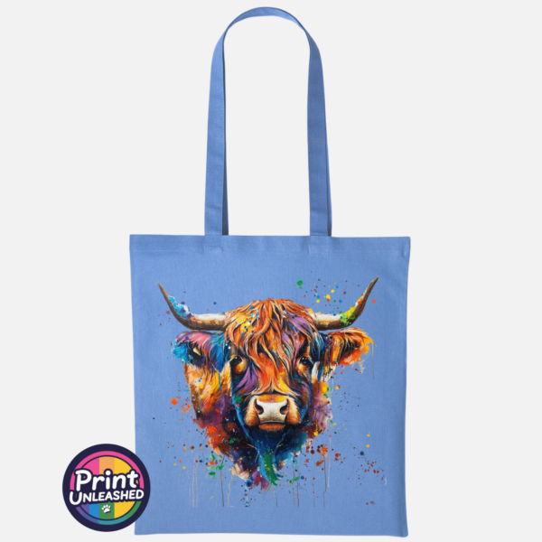 Highland cow portrait with a shaggy orange fringe, sweeping horns and vibrant blue, purple, yellow and green paint splashes printed on a tote bag cornflower blue - Print Unleashed