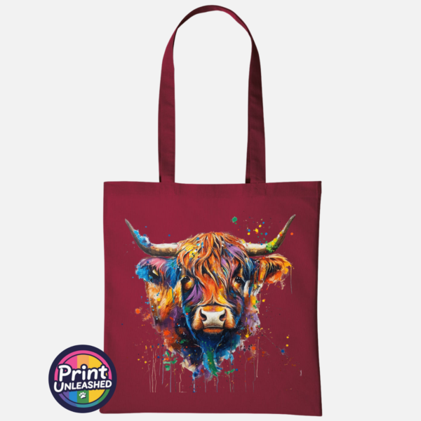 Highland cow portrait with a shaggy orange fringe, sweeping horns and vibrant blue, purple, yellow and green paint splashes printed on a tote bag deep red - Print Unleashed