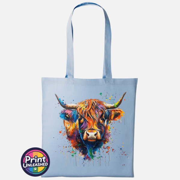 Highland cow portrait with a shaggy orange fringe, sweeping horns and vibrant blue, purple, yellow and green paint splashes printed on a tote bag sky - Print Unleashed