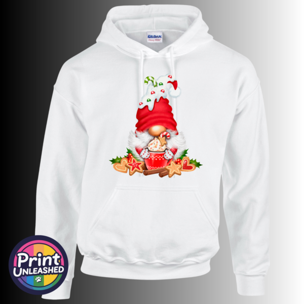 Christmas gonk in a red candy-cane-decorated hat holding a cream-topped cocoa mug, surrounded by iced biscuits, cinnamon and holly, printed on a white unisex hoodie - Print Unleashed