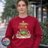 Gingerbread-style signpost pointing to Gingerbread Village, Peppermint Post, Cookie Kitchen and Gumdrop Lane, with sweets and biscuits, printed on a cherry red unisex sweatshirt female model - Print Unleashed