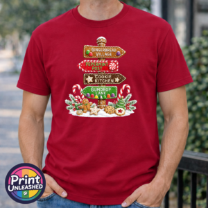 Signpost Gingerbread tee model male Gingerbread-style signpost pointing to Gingerbread Village, Peppermint Post, Cookie Kitchen and Gumdrop Lane, with sweets and biscuits, printed on a cherry red premium unisex T-shirt male model - Print Unleashed