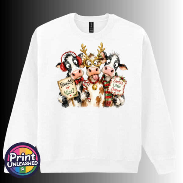 Three Christmas cows with reindeer antlers, earmuffs and signs reading Naughty or Nice and Santa’s Little Helper printed on a white unisex sweatshirt - Print Unleashed