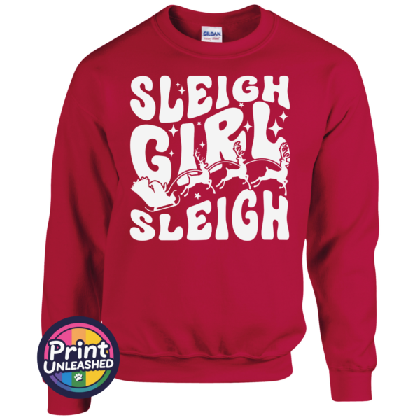 Sleigh Girl Bold retro-style Sleigh Girl Sleigh lettering with stars and a silhouette of Santa’s sleigh pulled by reindeer, printed on a cherry red unisex sweatshirt - Print Unleashed