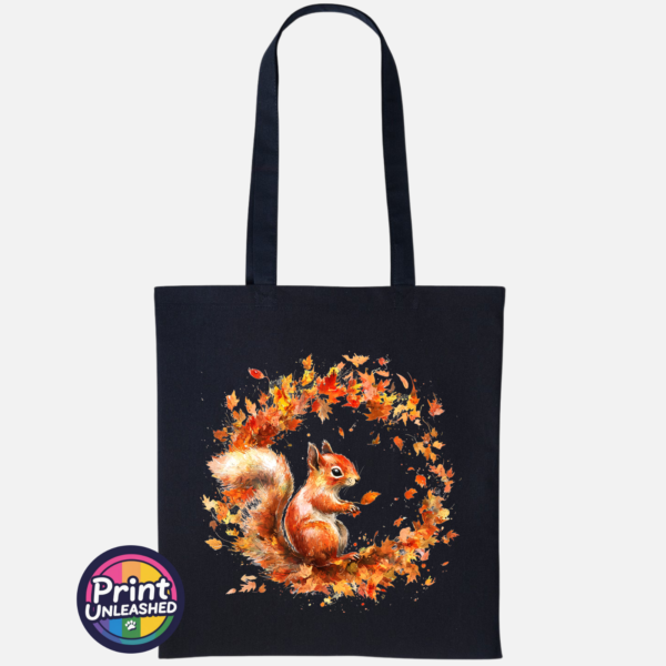 Red squirrel with a sweeping bushy tail surrounded by a swirl of orange, red and golden autumn leaves printed on a tote bag black - Print Unleashed