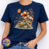 Copper, peach and cream wildflowers with delicate grasses and an orange butterfly printed on a navy unisex T-shirt model - Print Unleashed