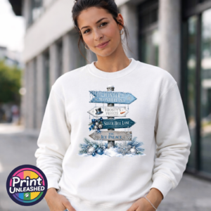 Snow-covered signpost pointing to Winter Wonderland, Frosty’s Freeze, Silver Bell Lane and the Ice Palace, with blue and silver decorations, printed on a white unisex sweatshirt female model - Print Unleashed