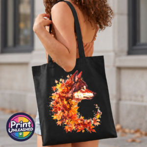 Wolf in profile with a golden eye and fur blending into red, orange and golden autumn leaves on a tote bag model - Print Unleashed