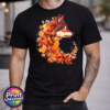 Wolf in profile with a golden eye and fur blending into red, orange and golden autumn leaves on a unisex T-shirt model - Print Unleashed