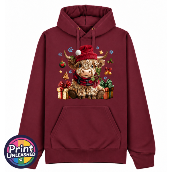 Model wearing a Classic Hoodie featuring a fluffy Highland calf in a red Christmas hat and checked scarf, surrounded by presents and festive decorations, pepper red colour - Print Unleashed