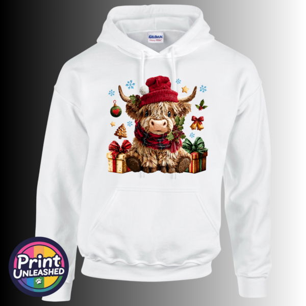 Yarn-style Highland cow wearing a red hat and checked scarf, surrounded by presents, holly, bells and snowflakes, printed on a white unisex hoodie - Print Unleashed