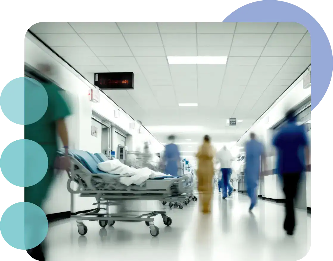 Hospital corridor with medical staff and empty patient bed in a healthcare facility.