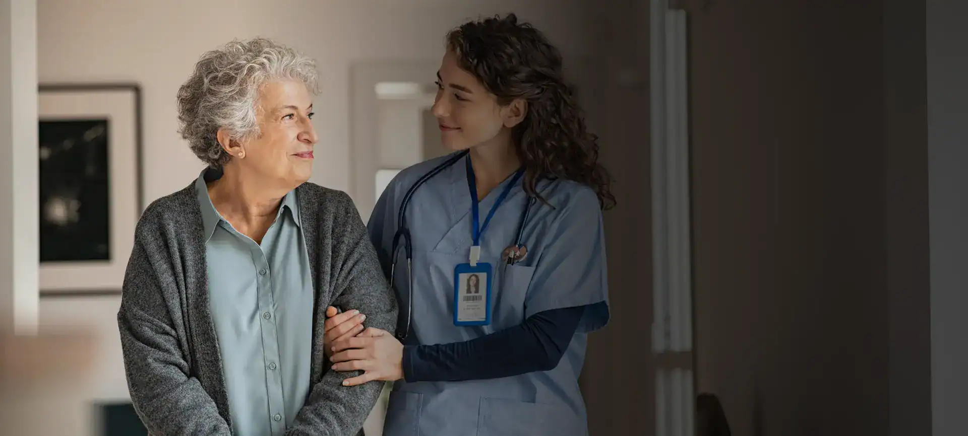 Nurse providing compassionate care to an elderly woman in a healthcare setting.