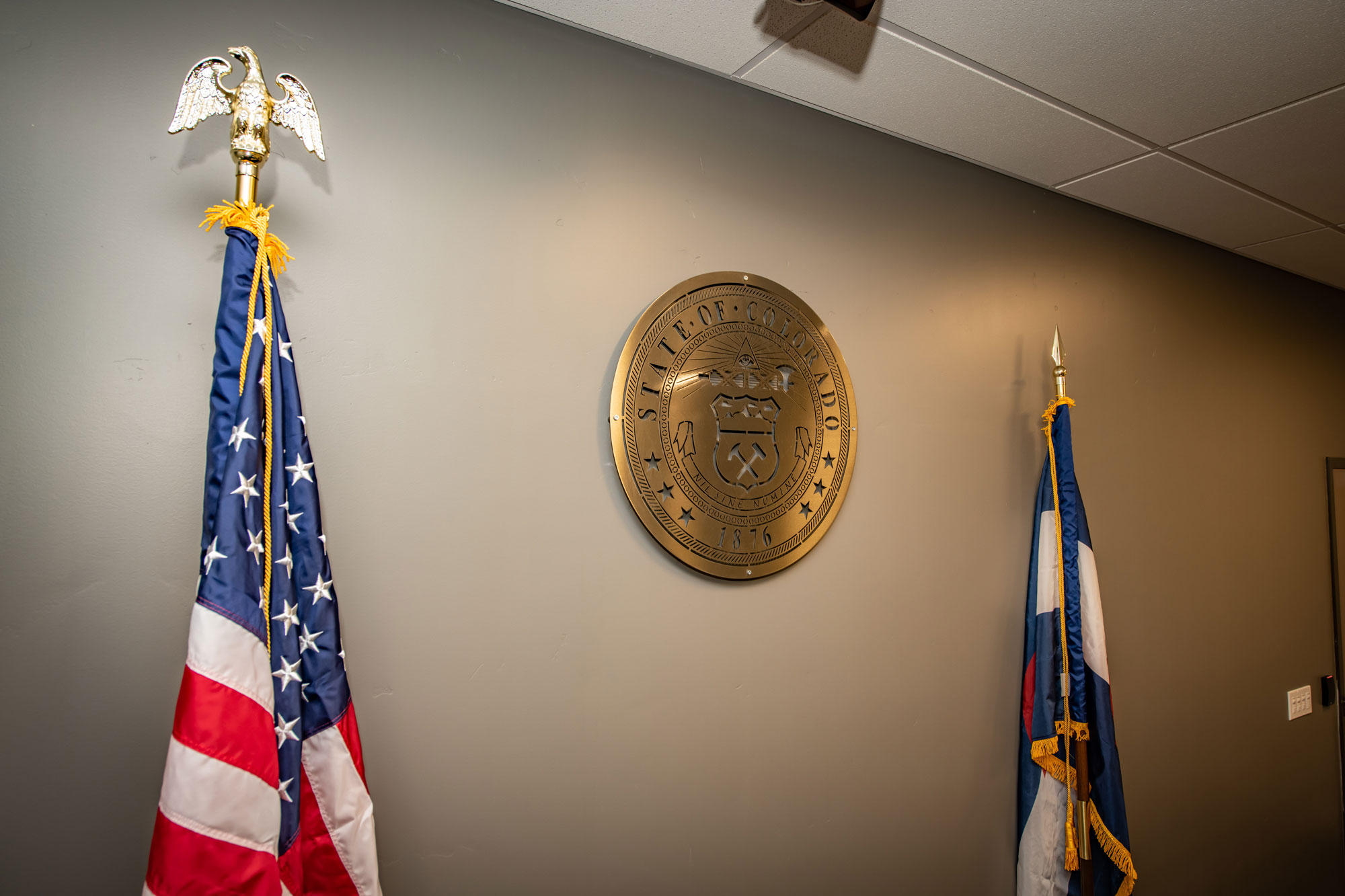 American flag and state seal wall decor in professional office setting.