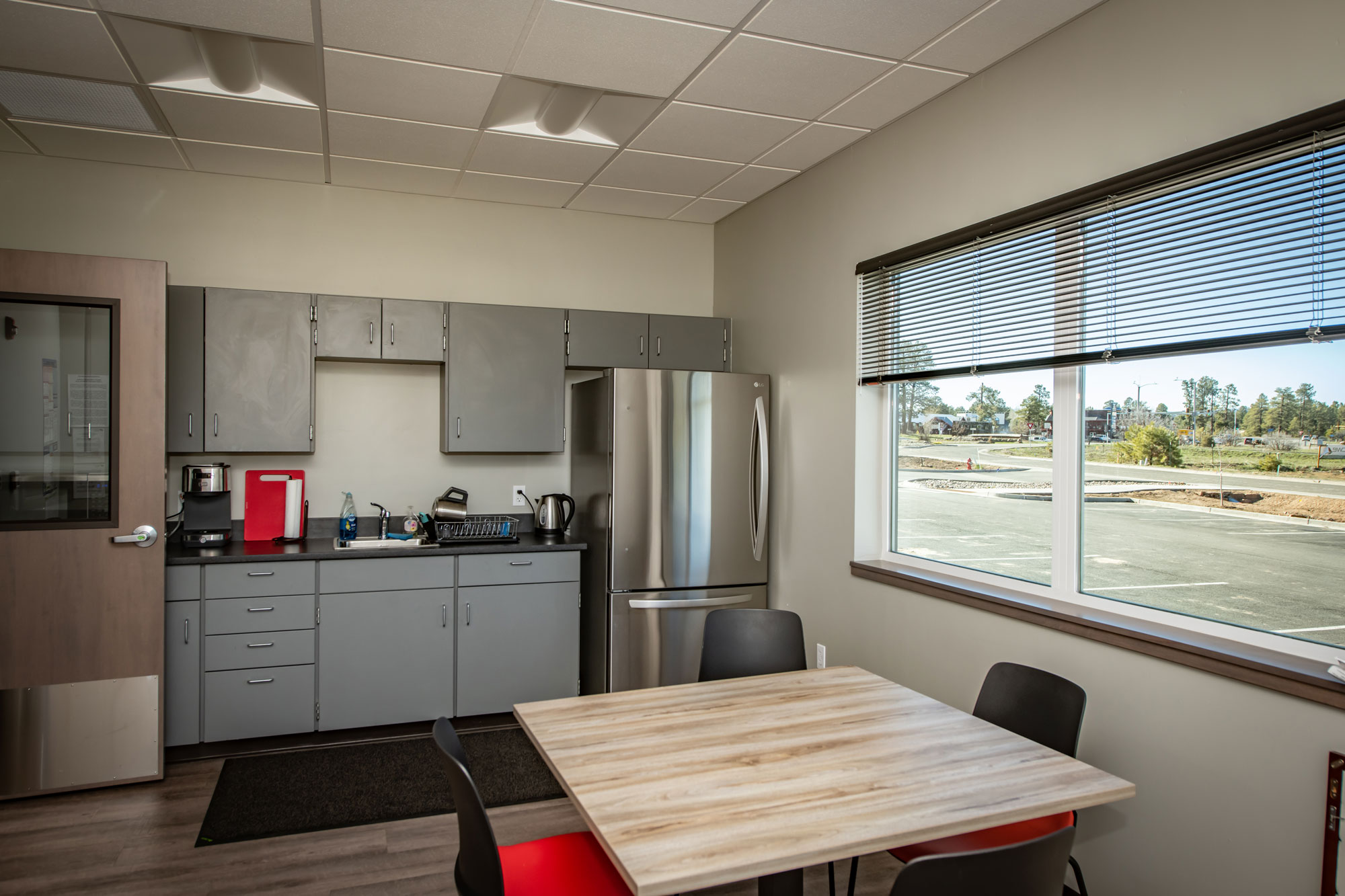 Office kitchenette with modern appliances and seating area.