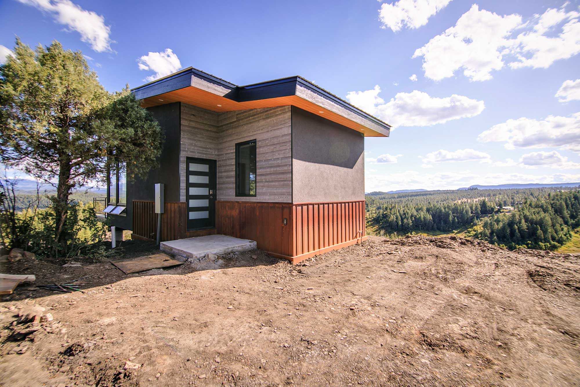 Modern cedar cabin with sleek design on a scenic hillside.