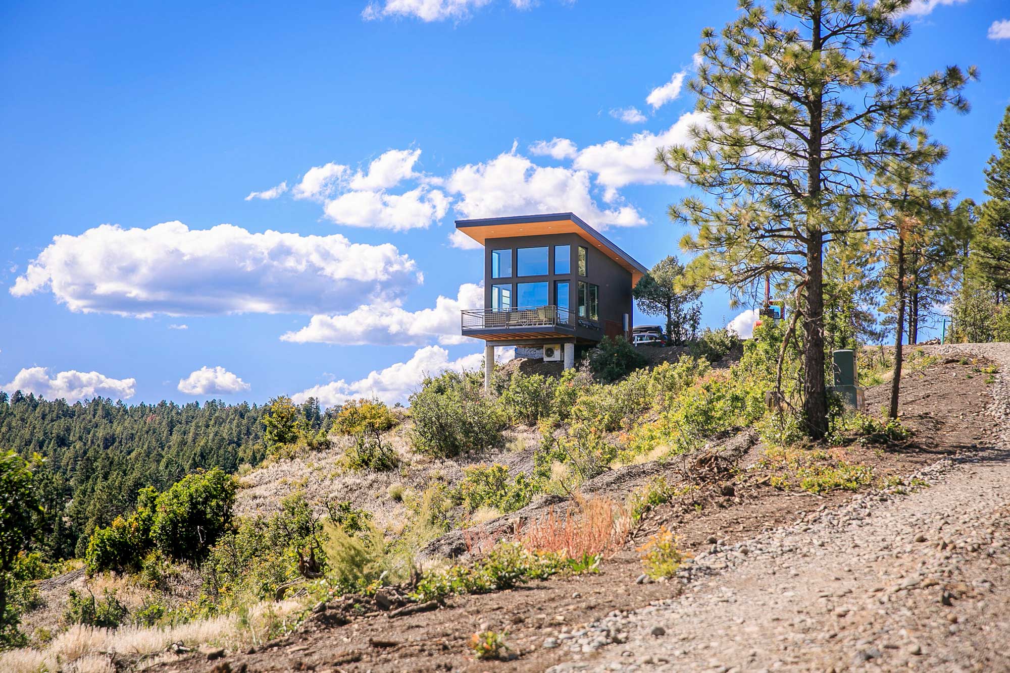 Modern cedar creek cabin perched on a hill with scenic mountain views.
