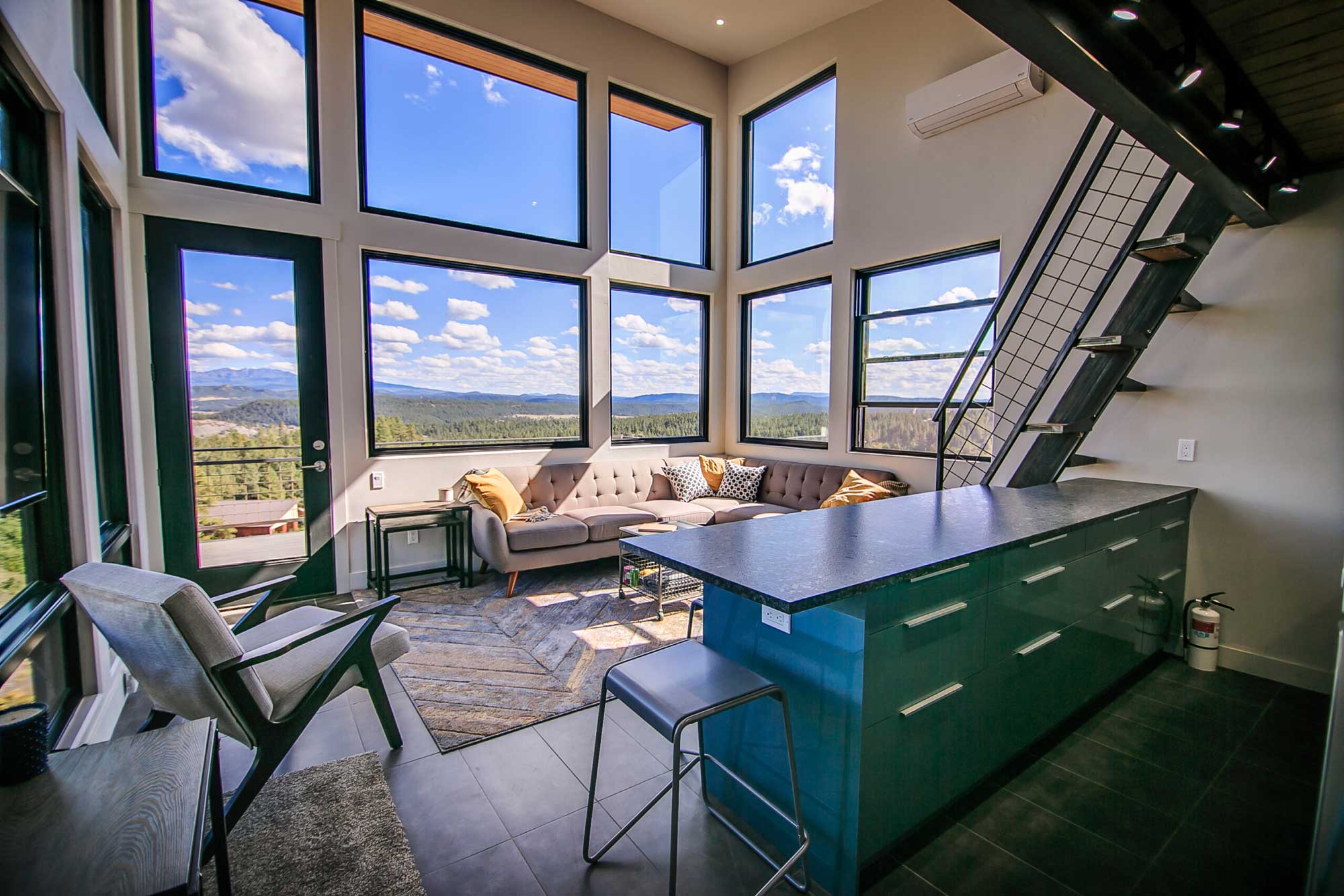 Modern cabin interior with large windows and scenic views.