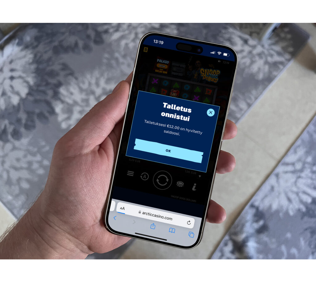 Pelaaja tekee talletuksen Arctic Casinolle Apple Pay -maksulla. Taustalla Snoop Dogg -kasinopeli.