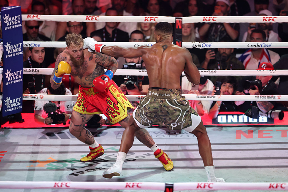 Anthony Joshua lyö Jake Paulia. Joshuan shortseissa näkyy Polymarket-logo ja kehän kulmauksessa näkyy DraftKings logo.