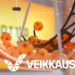 Veikkauksen logo, taustalla lottoarvontakone-