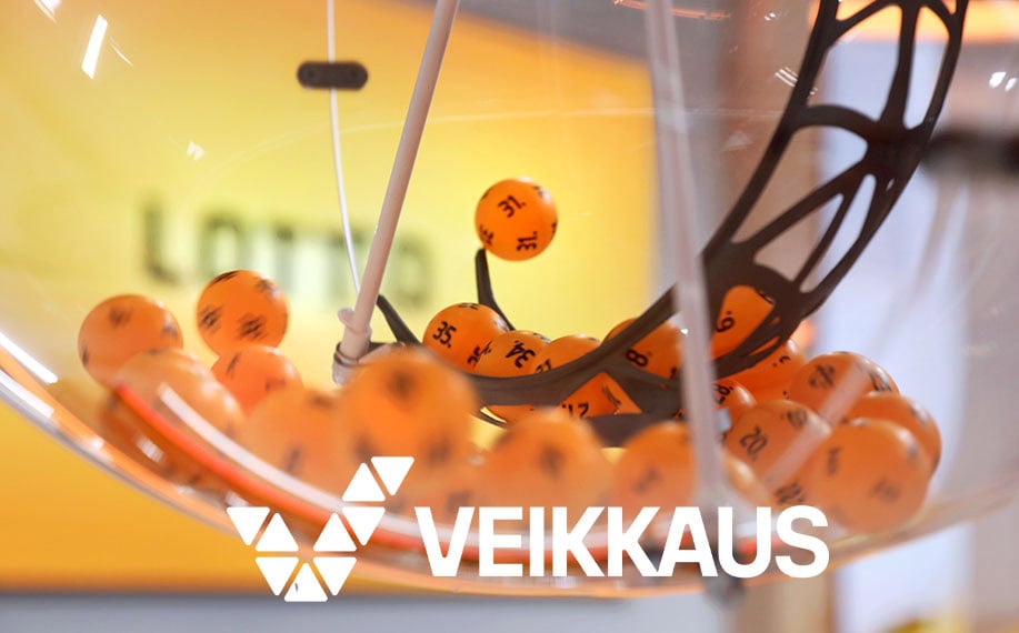 Veikkauksen logo, taustalla lottoarvontakone-
