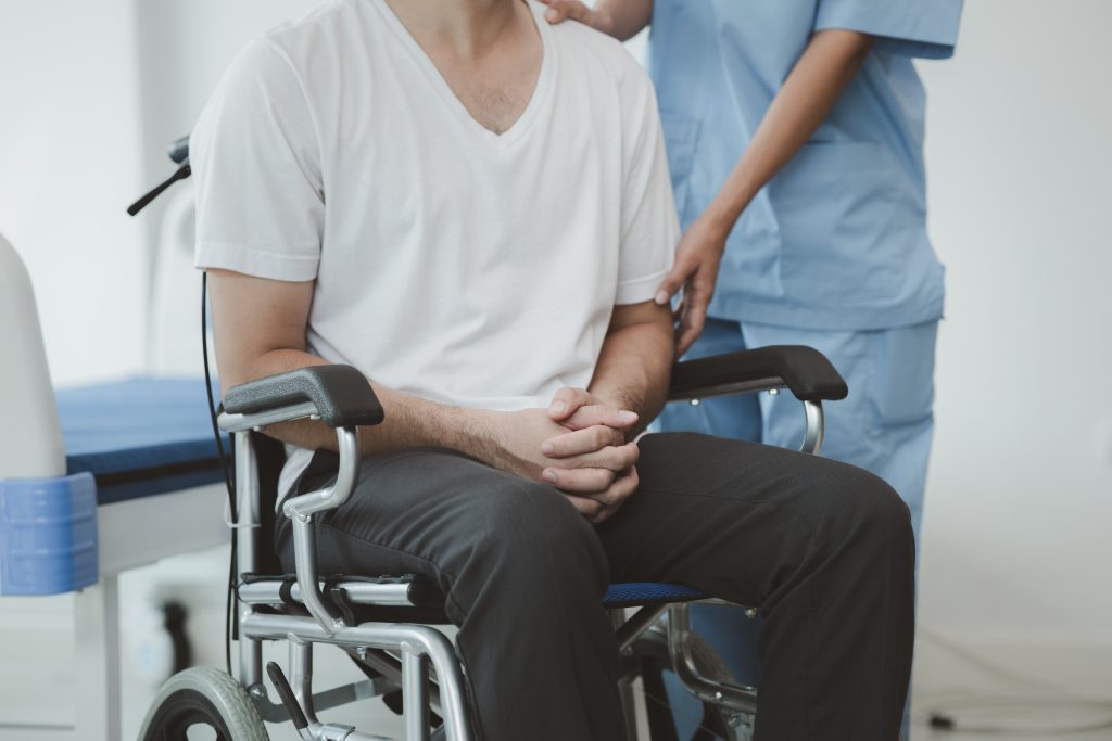 Male patient sitting in wheel chair after an accident.