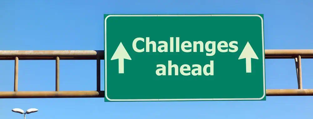 Challenges ahead Road sign that reads Challenge Ahead