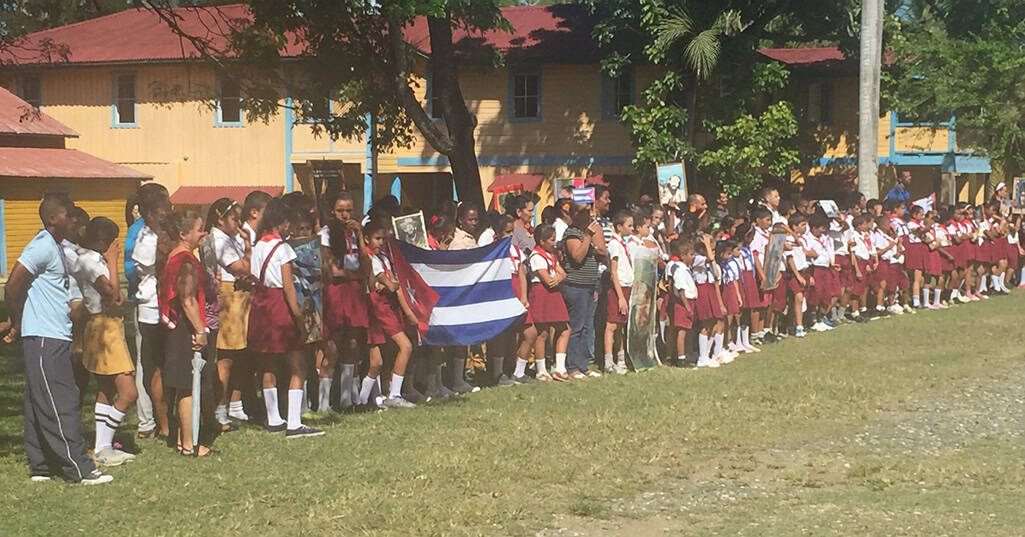 Commemorazione a Birán con bambini in divisa e bandiere cubane