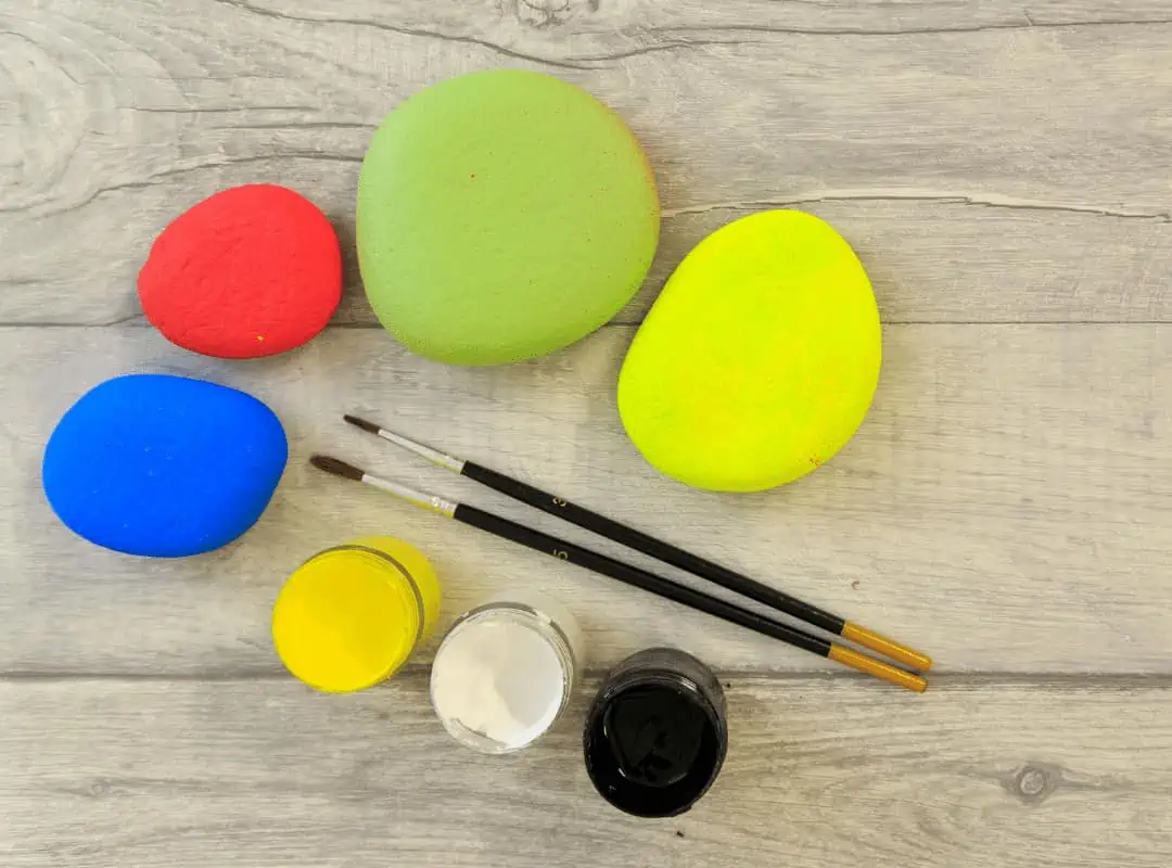 Complete Guide: How to Paint Rocks, Tips & Tricks, and Ideas to Try 6 base painted rocks in yellow, green red and blue paint