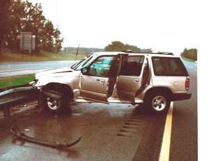 SUV involved in a car accident on the highway with front damage and debris.