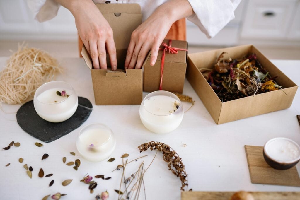 pexels photo 7233944 7233944 Close-up of handcrafted candles being packed with dried flowers and eco-friendly materials.