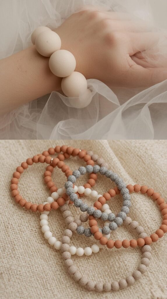 Neutral-toned clay bead bracelets with oversized beads in soft beige, muted terracotta, and stone gray. Styled on wrist or laid on natural fabric. 