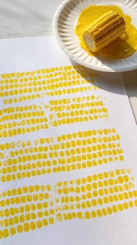Corn cob stamp painting with yellow kernel prints on white paper