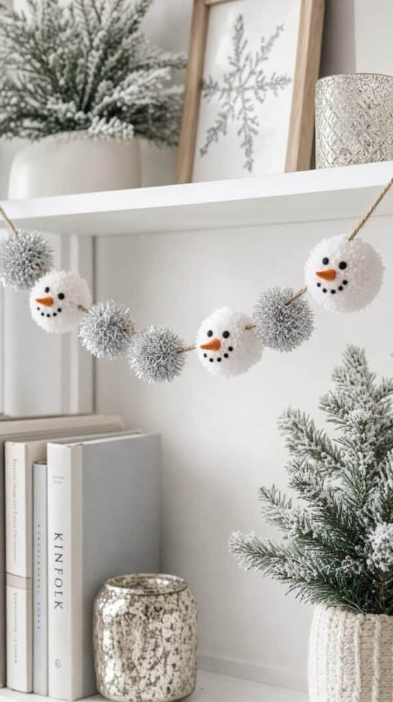 White pom pom snowman garland with felt noses hanging on a shelf