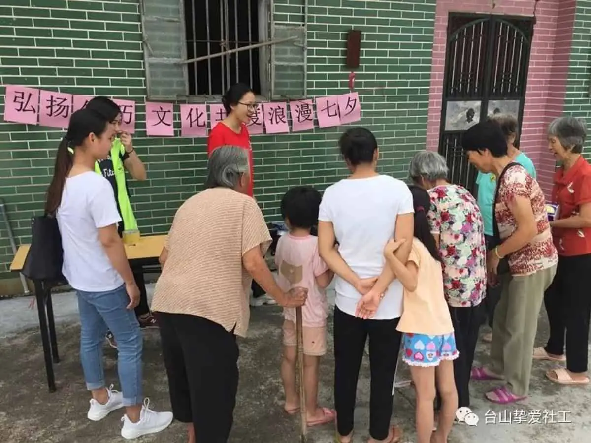 A man lighting incense at a Ning Yang clan ancestral altar — the offering rite that frames festival observance in the Wuyi qiaoxiang villages.