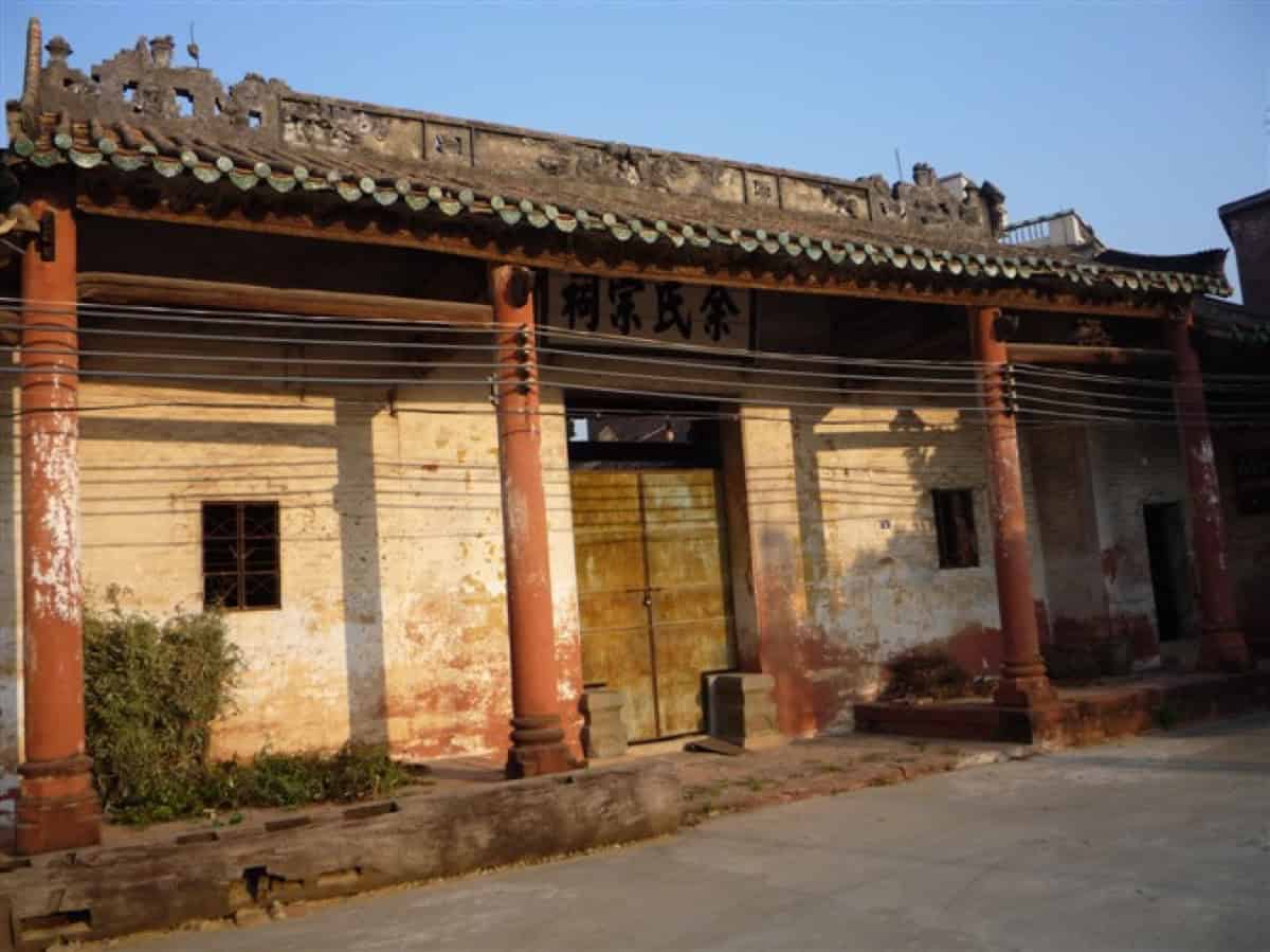 Facade of a Yu clan ancestral hall in Guangdong — weathered tiled roof, wooden columns, plaque reading Yu Clan Ancestral Hall (余氏宗祠)