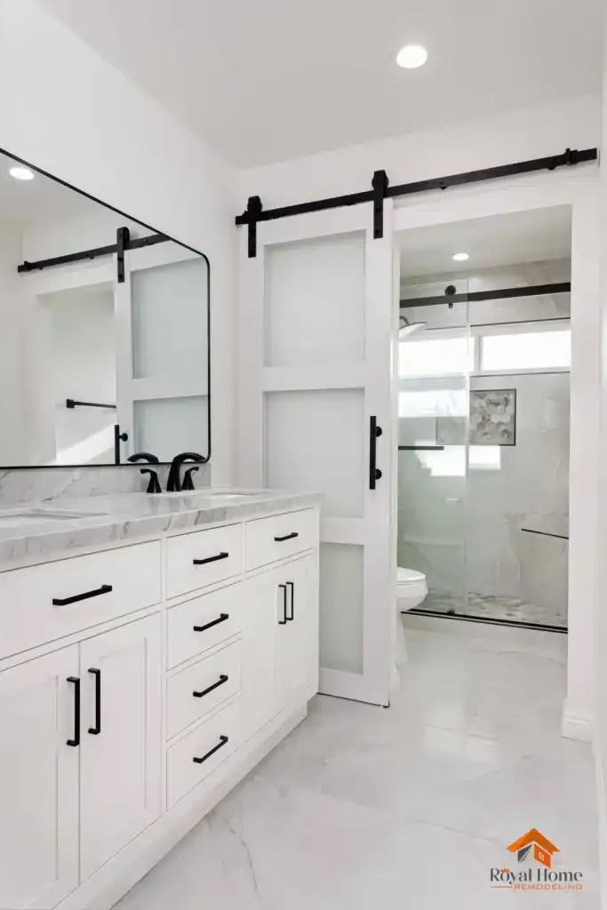 Modern bathroom with white vanity, marble countertop, and barn door