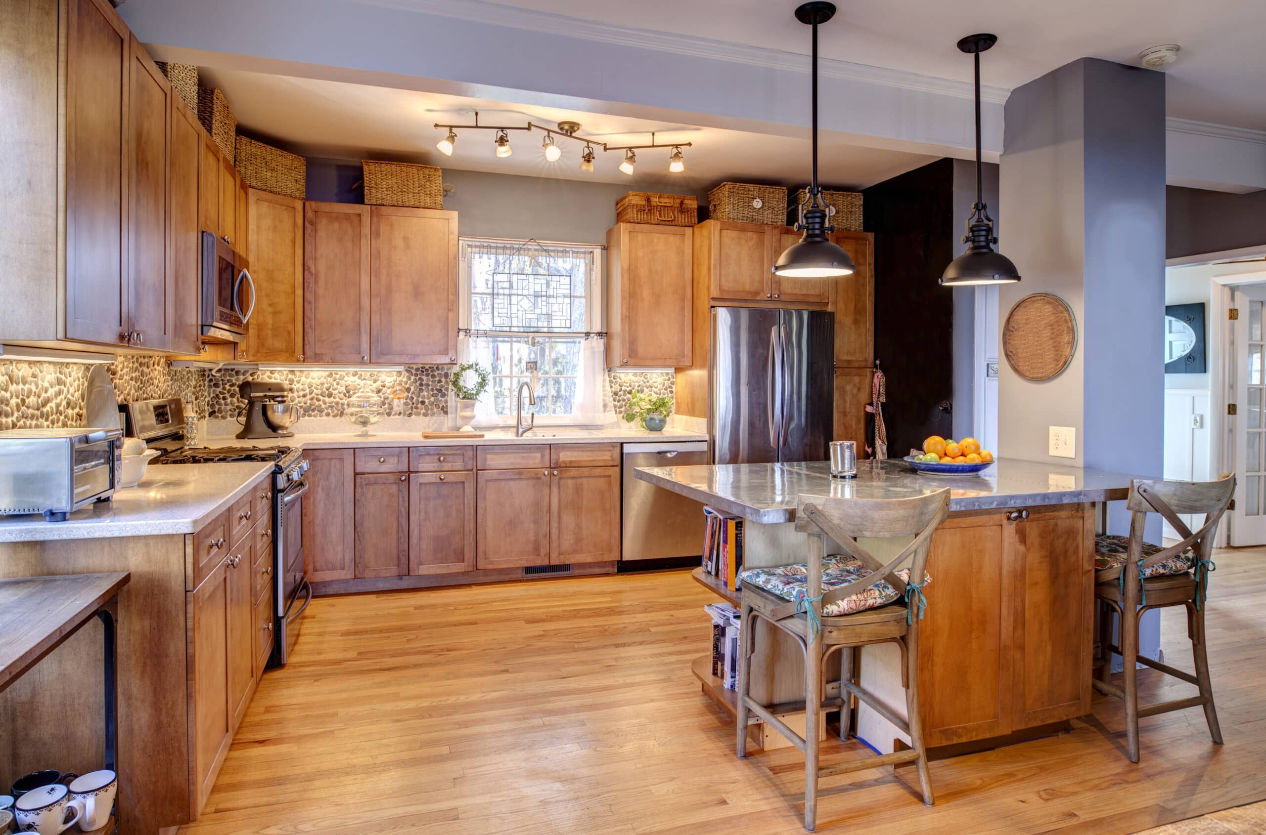Warm, inviting kitchen with wooden cabinets, stainless steel appliances, and a central island.