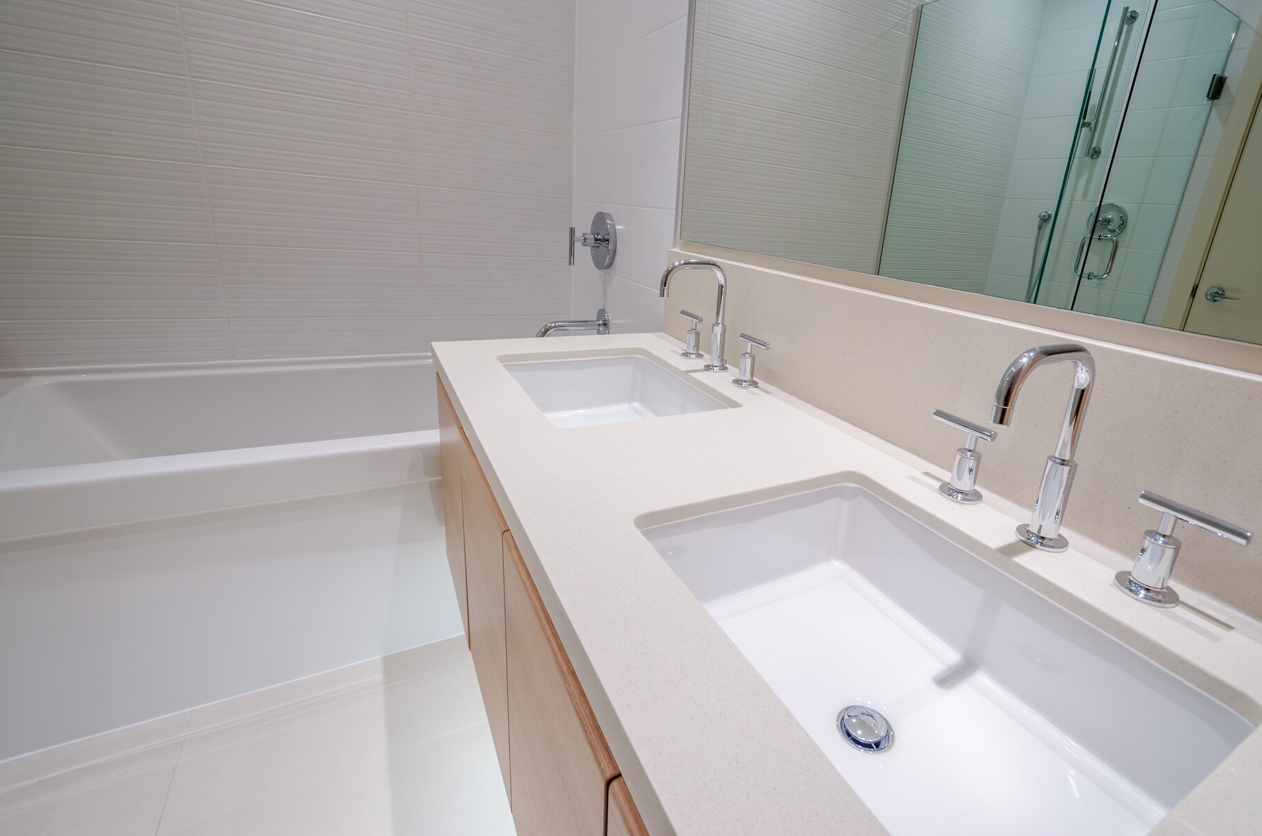 Modern bathroom with double vanity, two sinks, and a bathtub.