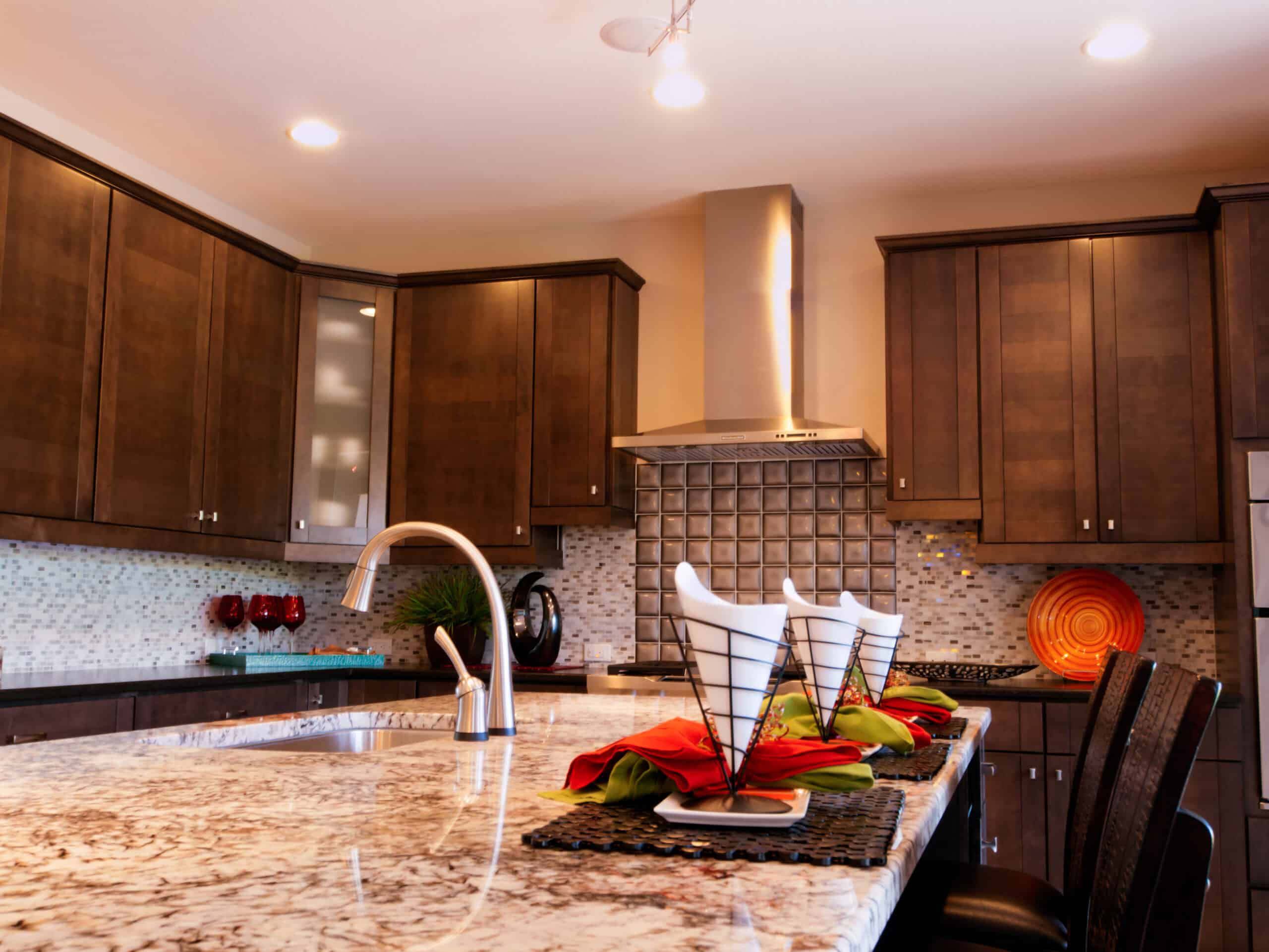 Modern kitchen with dark wood cabinets, granite countertops, and stainless steel appliances.