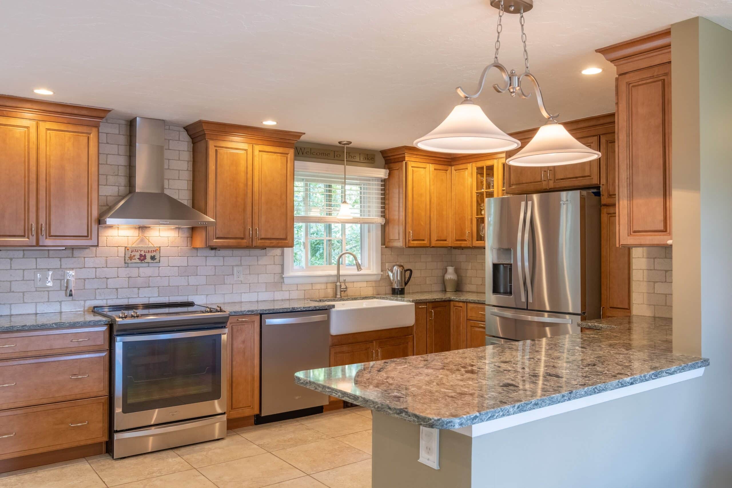 Modern kitchen with wooden cabinets, stainless steel appliances, and granite countertops.