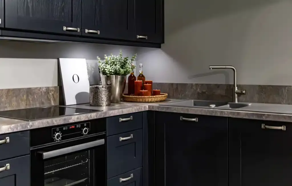 Modern dark blue kitchen with oven, sink, and decorative elements