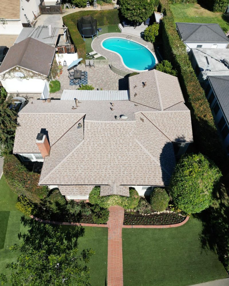 Aerial view of a house with a pool and manicured lawn