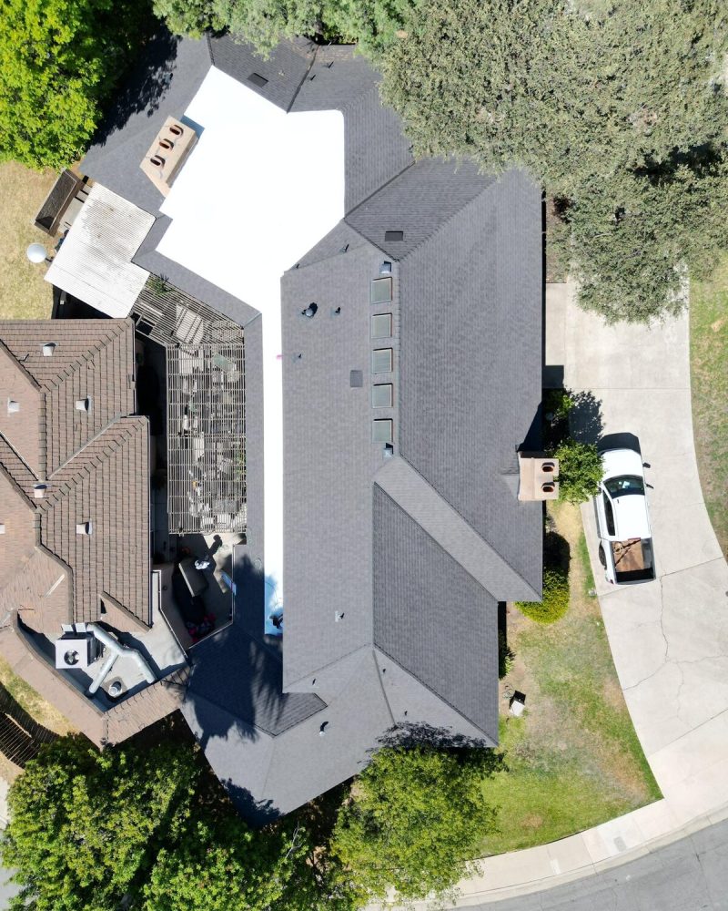 Aerial view of a house with a dark gray roof and white sections