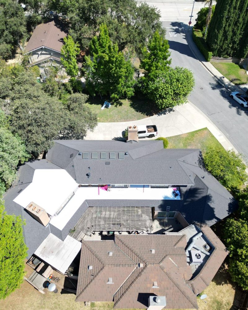 Aerial view of a large residential property with multiple buildings and a pool.