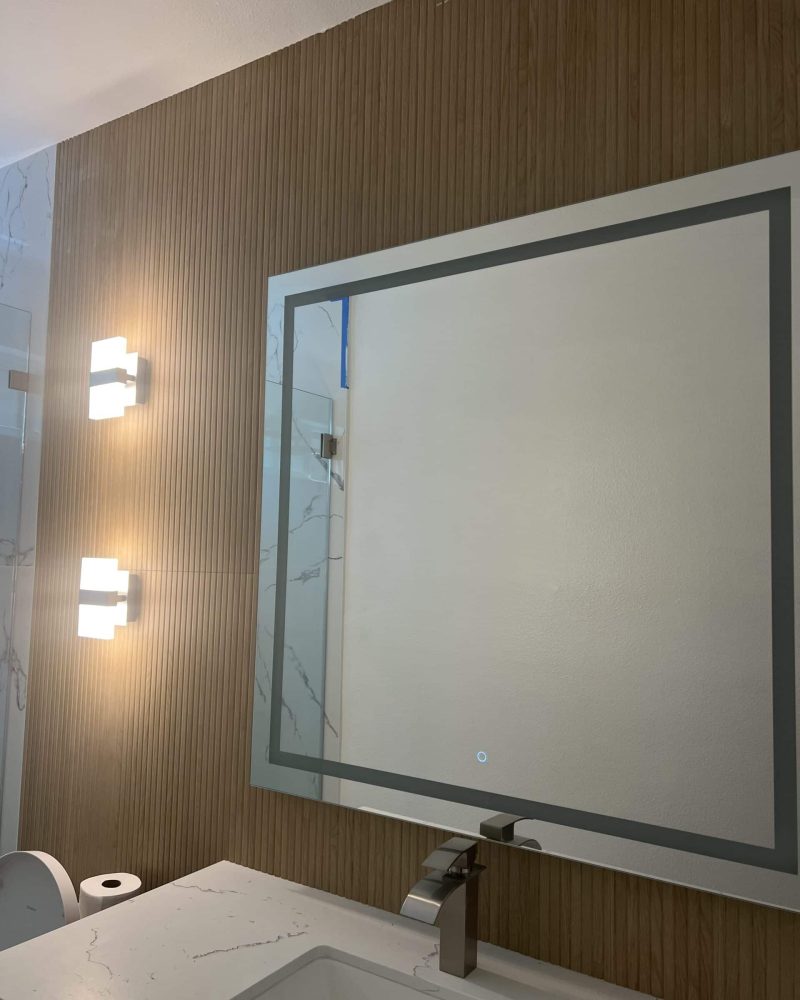 Bathroom vanity with mirror, sink, faucet, and wall-mounted lights.