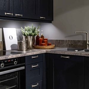 Modern kitchen with dark blue cabinets, stone countertops, and stainless steel appliances.