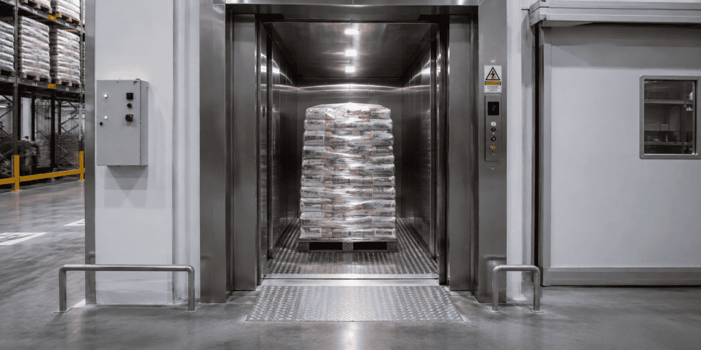 Elevador de carga para indústria alimentícia transportando pallets em ambiente industrial automatizado de alta produtividade