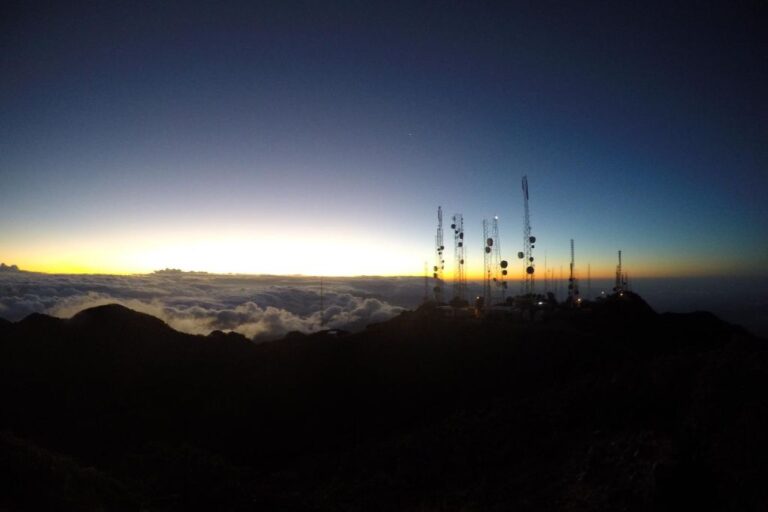 Sunrise view on Baru Vulcan from a high vantage point featuring silhouetted communication towers against a gradient sky, with clouds below reflecting the fading light. The 2025 Spiritual Guide to Boquete Panama.